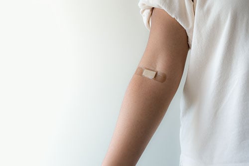 Close up of an arm with a bandaid where blood had been drawn