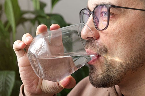 Man drinking water after taking a weight loss medication
